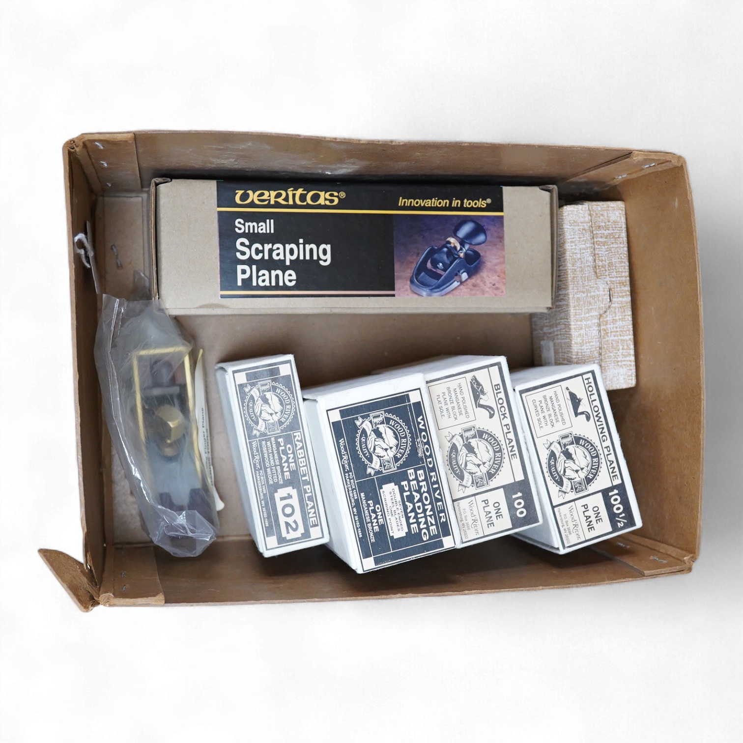 Seven planes by Veritas, Wood River, etc. including a boxed Veritas small scraping plane, four Wood River planes including a block plane, a beading plane, etc. A Harris Tools, brass finger plane, and a set of three minia